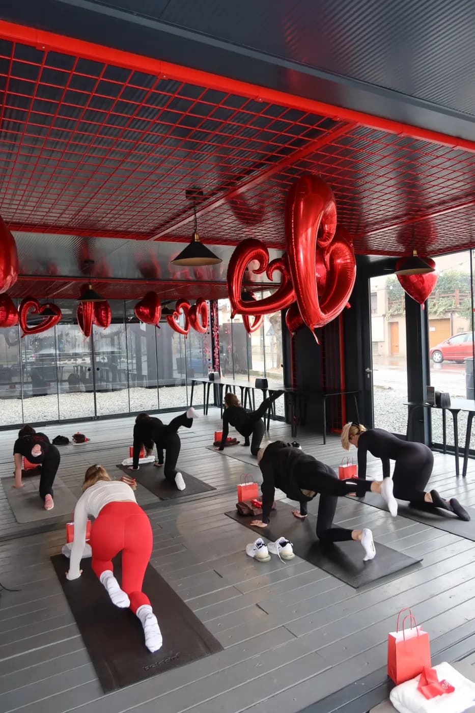 Clasa de pilates în patru labe, sub tavanul roșu și baloanele-inimă de la Foodie the Van