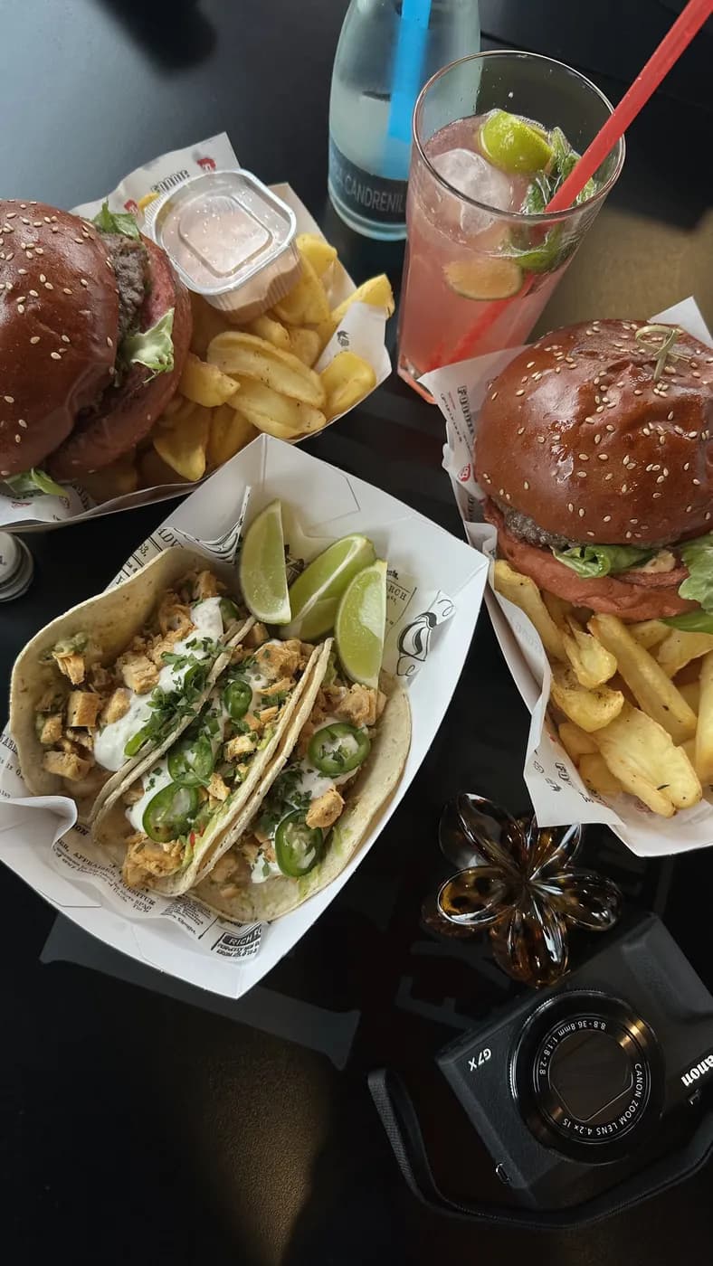 Burgeri, tacos, cartofi și limonadă roz pe masă, după clasă