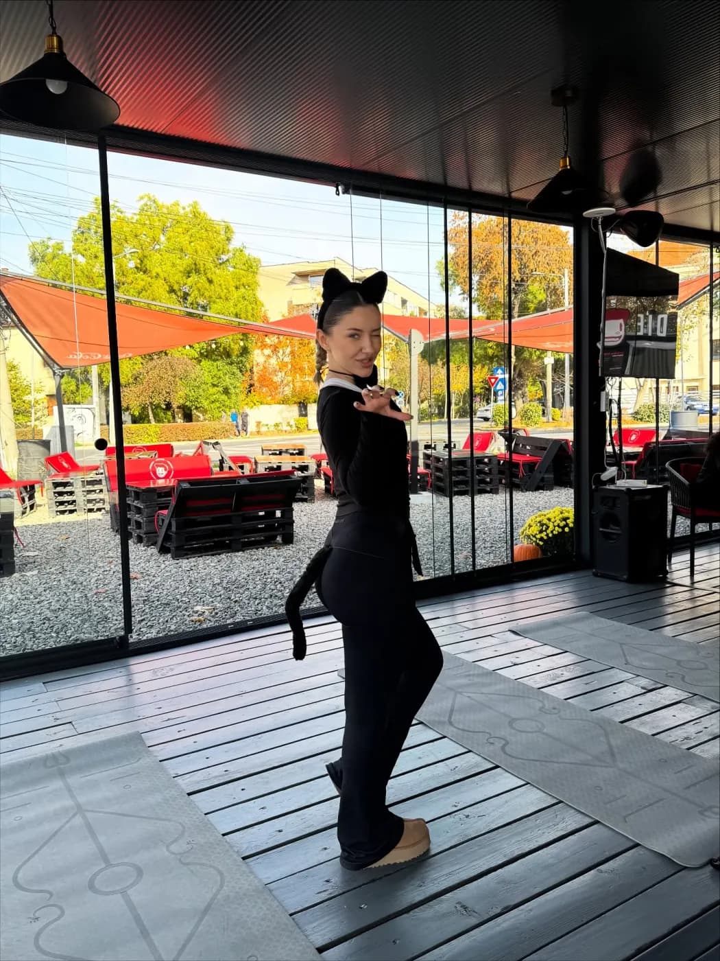 Participantă costumată în pisică, cu urechi și coadă, făcând cu ochiul